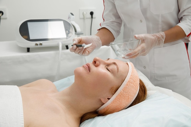 Una mujer recibe tratamiento con láser en la cara en una clínica de cosmetología. Se está desarrollando un concepto de rejuvenecimiento de la piel.
