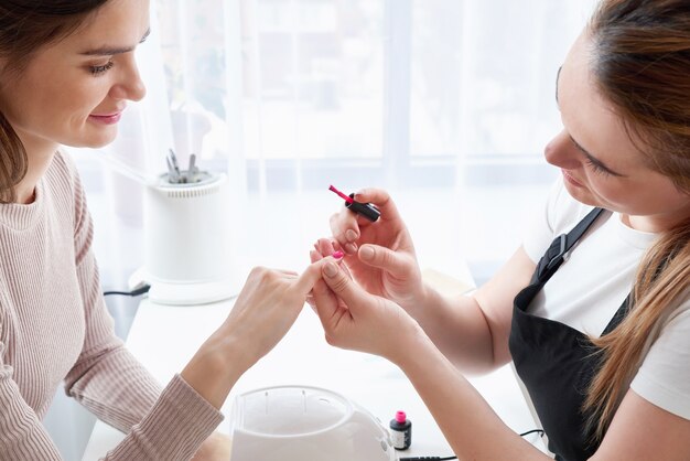 Mujer recibiendo una manicura en el salón de uñas