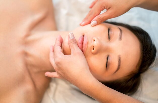 Foto mujer recibiendo un masaje facial en el spa 348