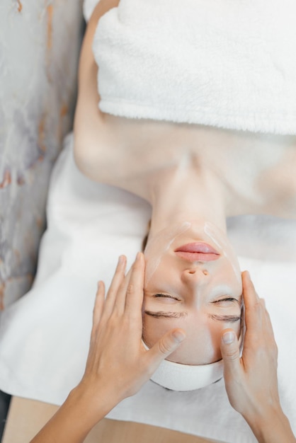 Una mujer recibiendo un masaje facial en el spa.