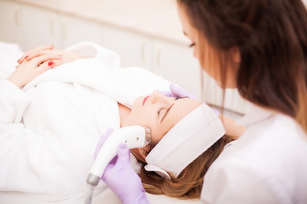 Mujer recibiendo masaje de hardware de GLP en la clínica de belleza. Esteticista profesional trabajando