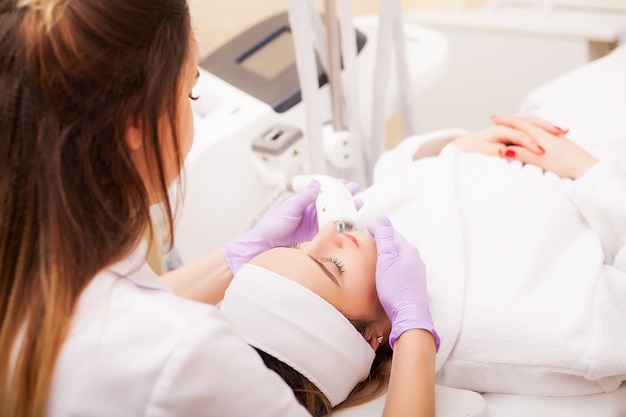 Mujer recibiendo masaje de hardware de GLP en la clínica de belleza. Esteticista profesional trabajando