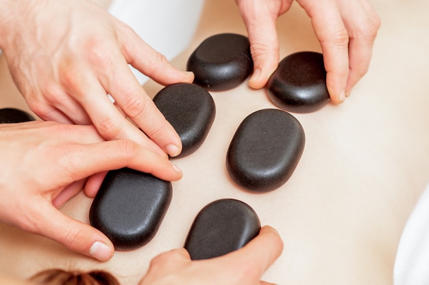 Mujer recibiendo un masaje con piedras calientes.