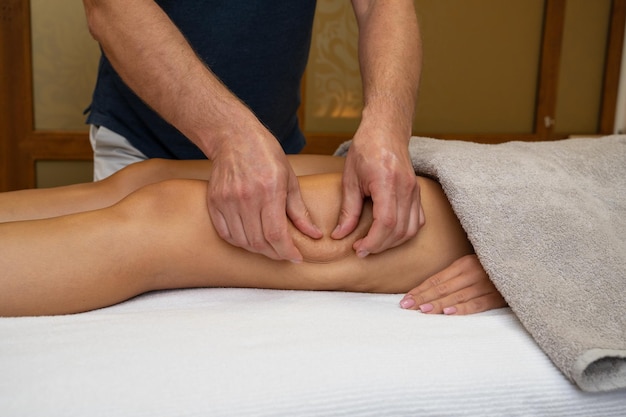 Mujer recibiendo masaje de piernas en el salón de spa