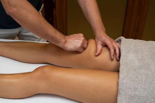 Mujer recibiendo masaje de piernas en el salón de spa