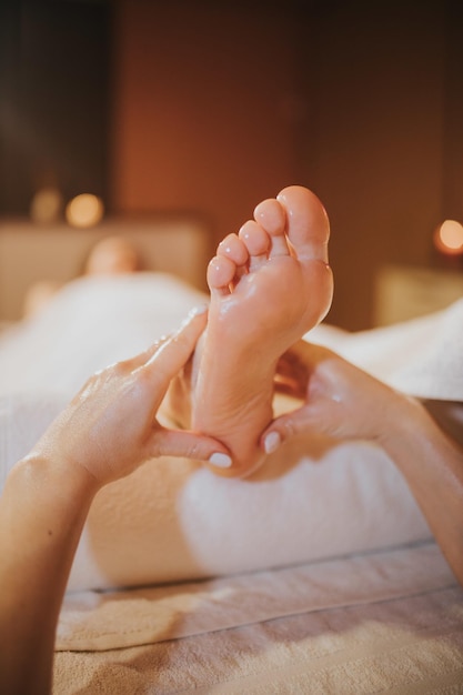 Mujer recibiendo un masaje de pies profesional en un salón de spa de belleza - concepto de tratamiento de belleza