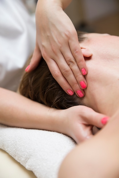 Mujer recibiendo un masaje de presión en el cuello para aliviar el estrés por un terapeuta de salud