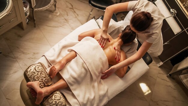 Mujer recibiendo un masaje de relajación en un salón de belleza vista de alto ángulo