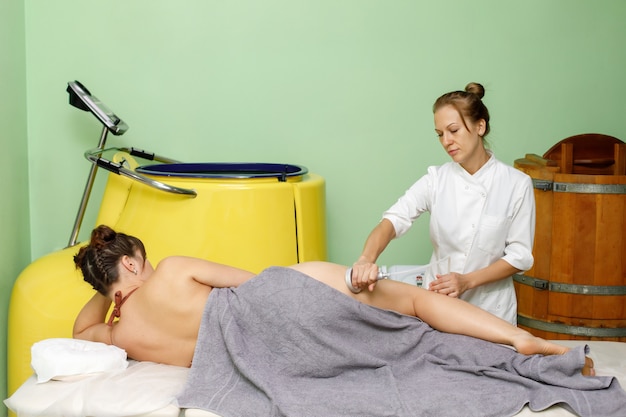 Mujer recibiendo procedimiento de masaje al vacío en salón de belleza