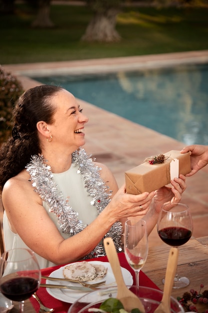 Foto mujer recibiendo un regalo de navidad en el hemisferio sur