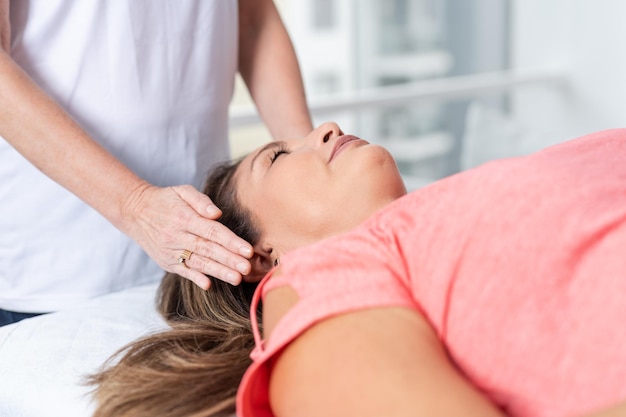 Mujer recibiendo una sesión de reiki en una clínica