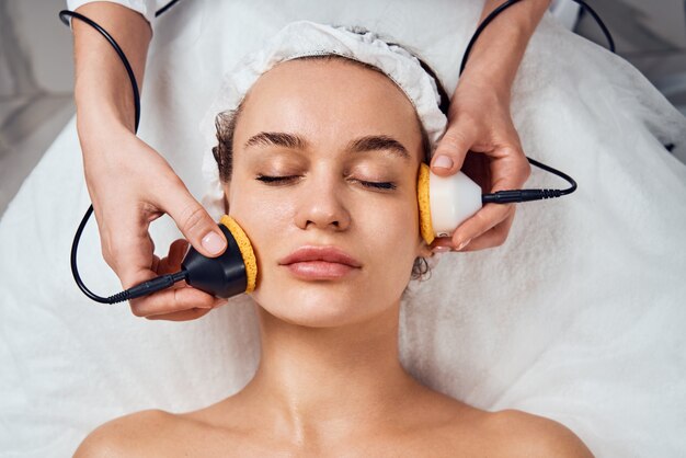 Mujer recibiendo tratamiento facial cosmético en la clínica