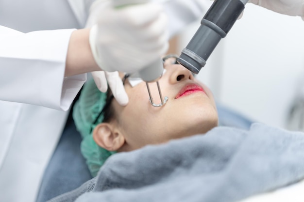 Foto mujer recibiendo tratamiento facial con láser pico en una clínica de belleza