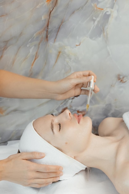 Una mujer recibiendo un tratamiento facial en un spa.