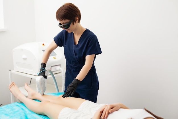 Mujer recibiendo tratamiento con láser en un salón de belleza.