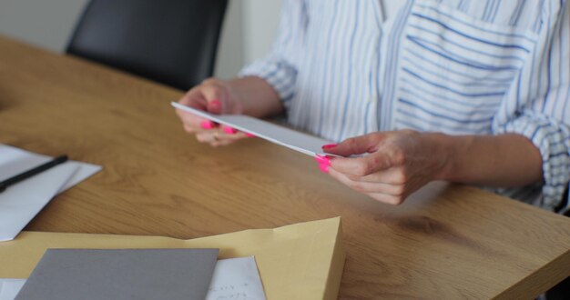 La mujer recibió una carta con una tarjeta de felicitación de cerca Las manos de la mujer sacan la carta de felicitación del sobre