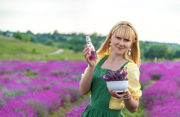 Una mujer recoge lavanda para aceite esencial Enfoque selectivo