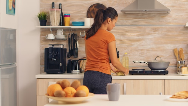 Mujer recogiendo huevos de la nevera para cocinar el desayuno. . Ama de casa sacando huevos y otros ingredientes del frigorífico de su cocina.