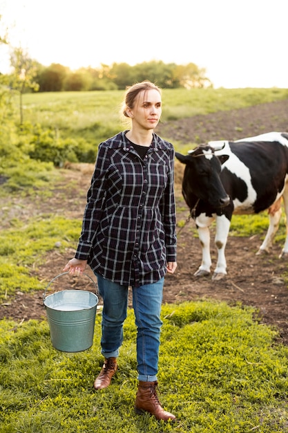 Mujer recogiendo leche de vaca