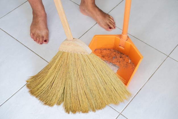 Foto mujer recortada barriendo el piso sucio