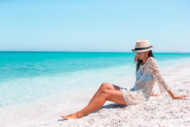 Mujer recostada en la playa disfrutando de las vacaciones de verano mirando al mar