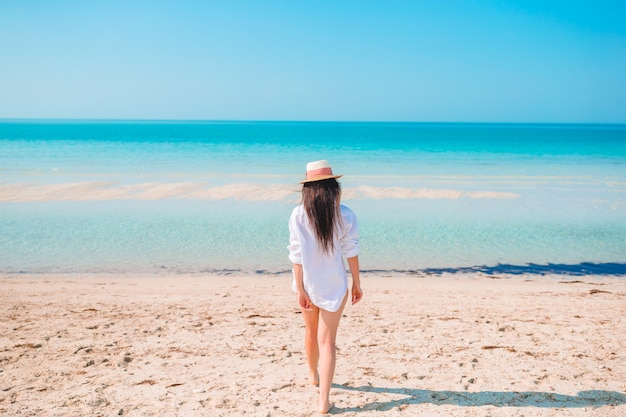 Mujer recostada en la playa disfrutando de las vacaciones de verano mirando al mar