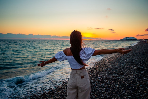 Mujer recostada en la playa disfrutando de las vacaciones de verano mirando el mar