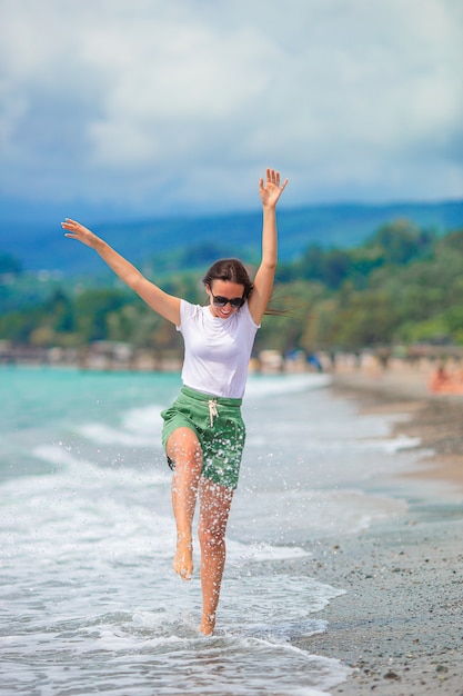 Mujer recostada en la playa disfrutando de las vacaciones de verano mirando el mar