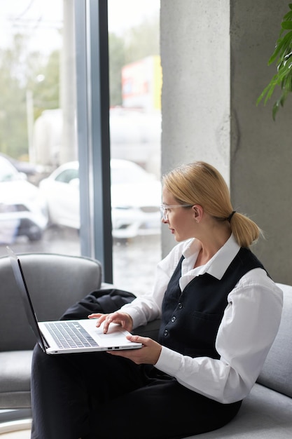 Foto mujer redactora usando una computadora portátil escribiendo en el teclado trabajando en un proyecto independiente en el lugar de trabajo