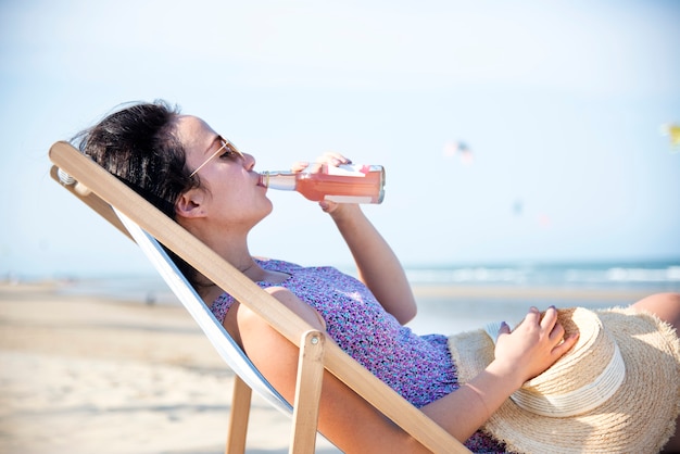 Mujer de refrigeración en la playa