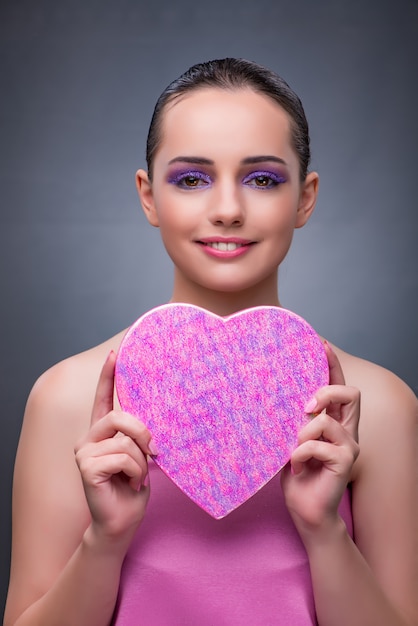 Foto mujer con regalo en caja en forma de corazón.