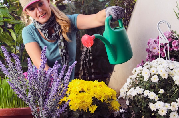 Mujer regando jardín botánico de la casa