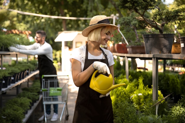 Mujer regando plantas tiro medio