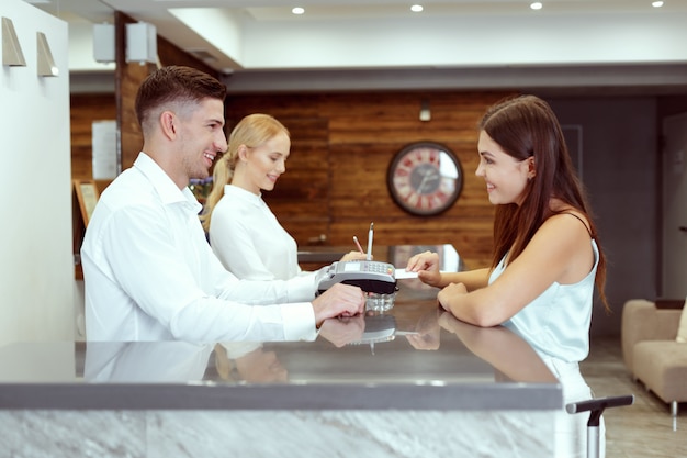 Foto mujer registrarse en la recepción del hotel