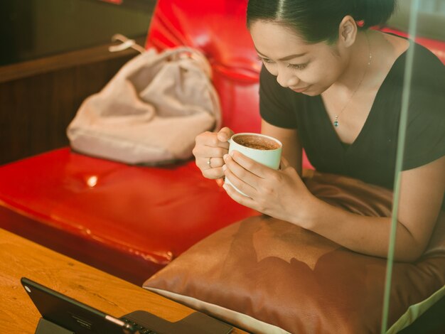 La mujer se relaja con su café en el café.