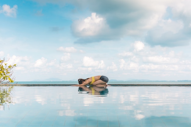 Foto mujer se relaja en yoga pose del niño