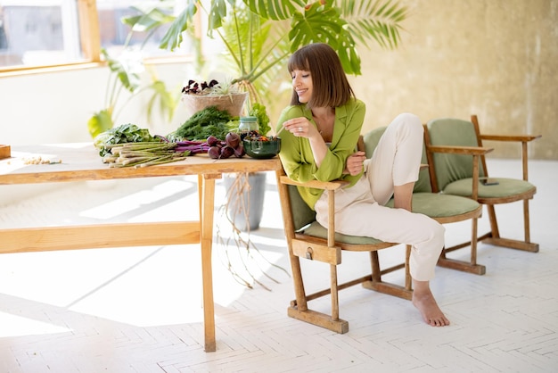 Mujer relajada con comida saludable en la habitación con plantas.