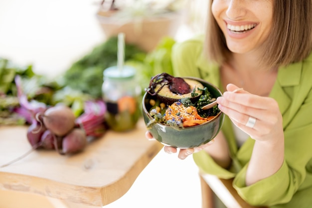 Mujer relajada con comida saludable en la habitación con plantas.