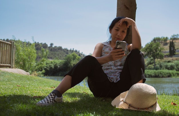 mujer relajada mirando el teléfono inteligente