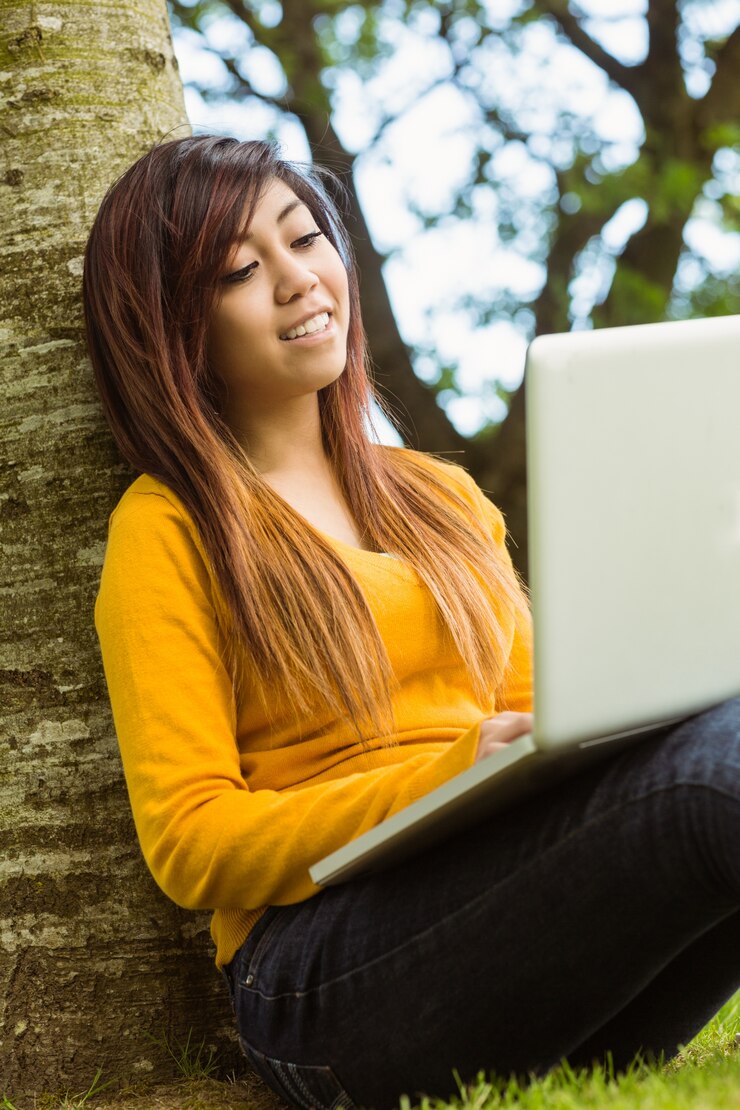 Foto mujer relajada que usa la computadora portátil en el parque