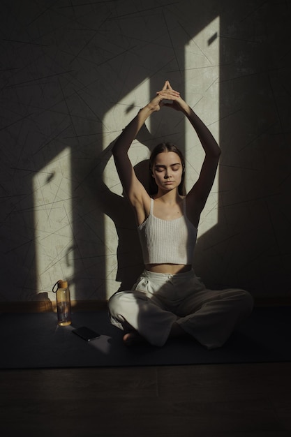 Mujer relajada sentada en Padmasana con gesto mudra en manos levantadas