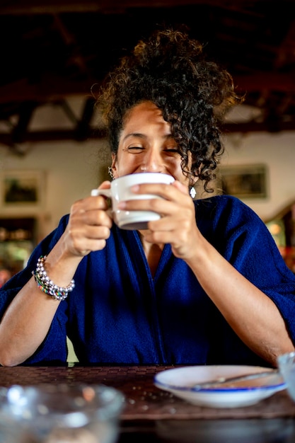 Foto mujer relajada sonriendo y bebiendo una taza de café