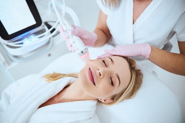 Mujer relajada sonriente disfrutando del procedimiento cosmético