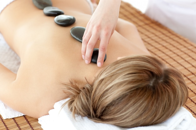 Mujer relajada teniendo una terapia de piedra