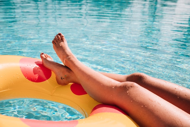 Foto mujer relajando al lado de piscina