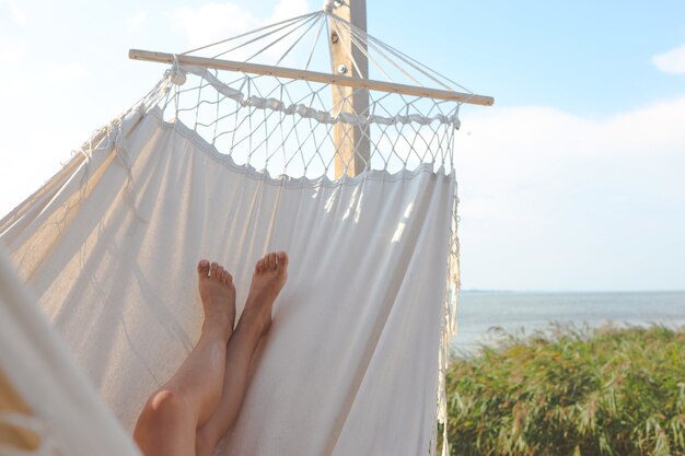 Mujer relajándose en la hamaca en la playa