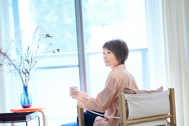 Mujer relajándose junto a la ventana