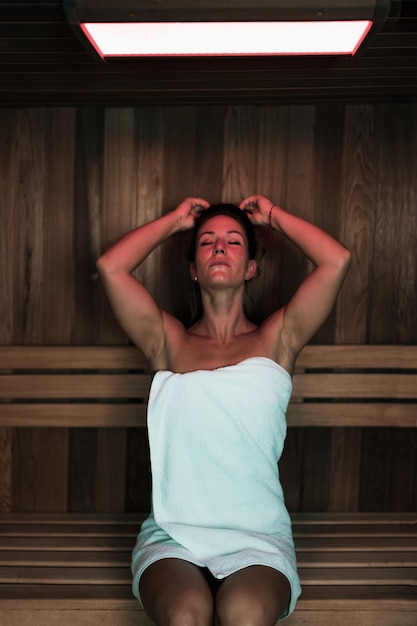 Foto mujer relajándose en la sauna