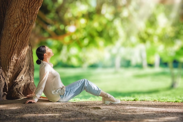 mujer, relajante, debajo, grande, árbol