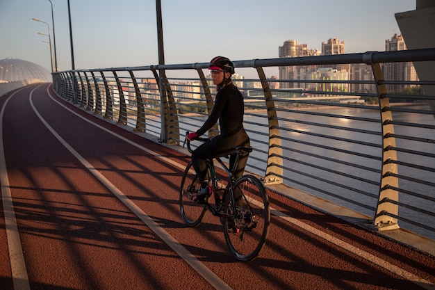 Mujer relajante después del entrenamiento de ciclismo por la mañana